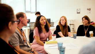Tara Sabre Collier speaking to other convening attendees. 