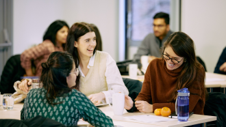 A group of Impact Lab students chatting at a retreat. 