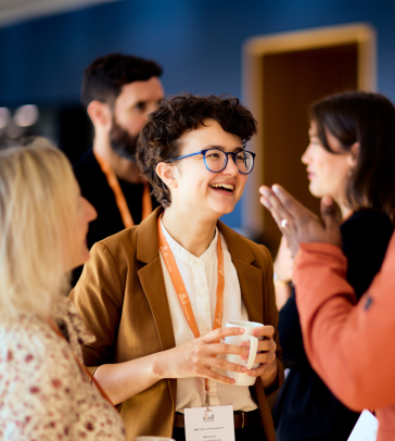 Elizaveta Belkina smiling and chatting to Lennon at the Skoll Community Convening.