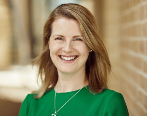 Mary Johnstone-Louis standing in the SBS hallway wearing a green top and smiling. 