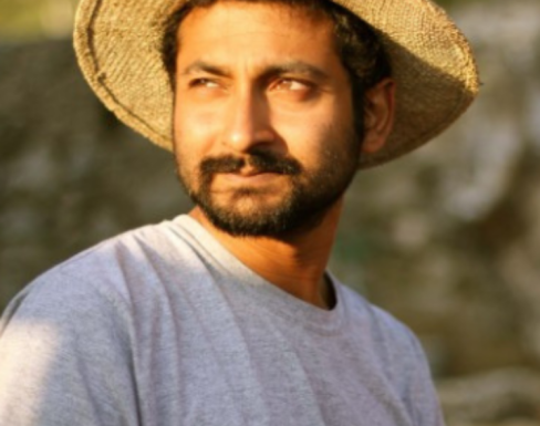 Aaron Pereira wearing a straw hat in the sun. 