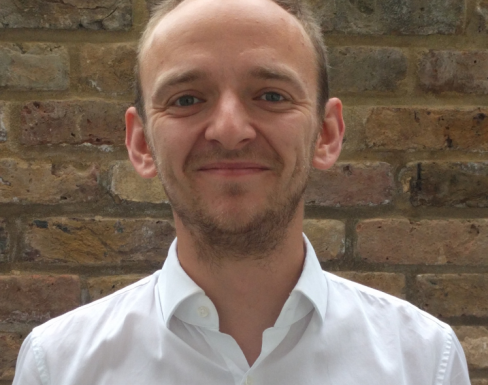 Alex Shapland Howes smiling and wearing a white shirt.