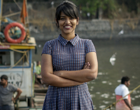 Asha standing against a backdrop of the ocean. 