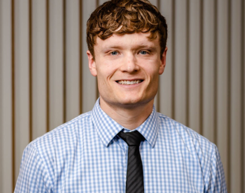 Jack Replinger smiling and wearing a light blue shirt.