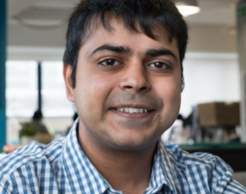 Nikhil Saigal wearing a blue shirt and smiling.