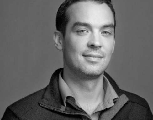 Shawn Smith smiling wearing a jumper. 