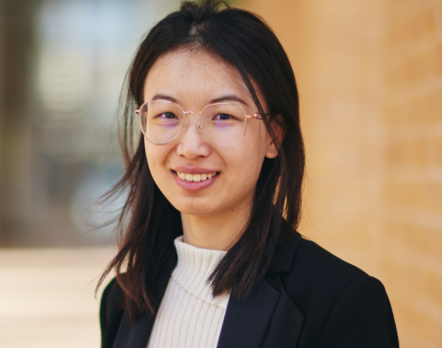 Pu Yang smiling wearing a black blazer and smiling. 
