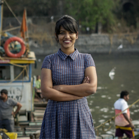Asha standing against a backdrop of the ocean. 