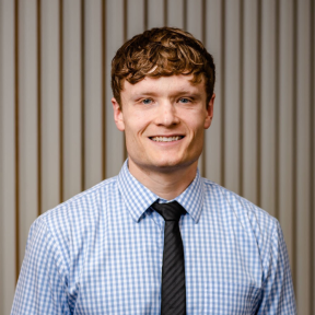 Jack Replinger smiling and wearing a light blue shirt.