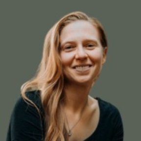 Jessica Lax in front of a teal background, smiling in a black top.