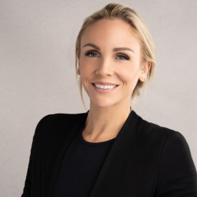 Kjerstin wearing a black suit and smiling.