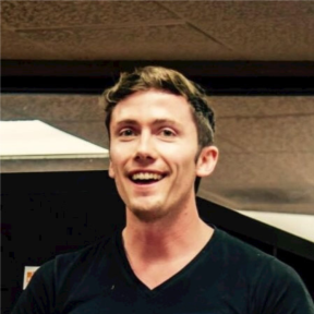 Mark Hlady wearing a black t-shirt and smiling. 