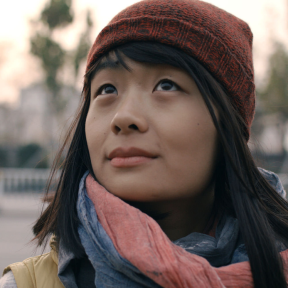Songqiao Yao wearing a hat and looking of into the distance. 