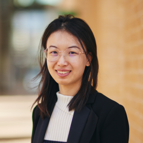 Pu Yang smiling wearing a black blazer and smiling. 