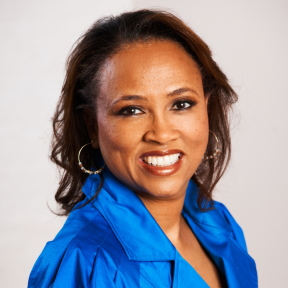 Cheryl is wearing a bright blue shirt and smiling. 